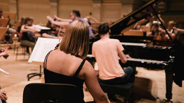 A female playing the violin in a big band